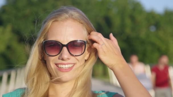 PORTRAIT: Cheerful Caucasian woman plays with her beautiful long blonde hair. - Footage, Video