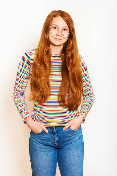 Stúdió portré csinos fiatal tini lány hosszú vörös haj, pózol fehér háttér - Fotó, kép