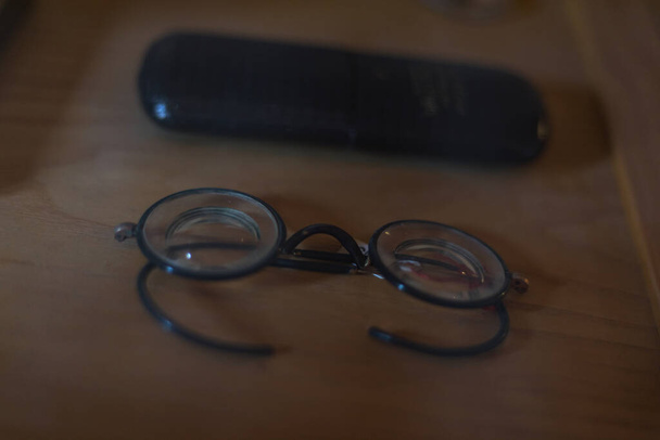  Eine sehr alte Brille in einem alten verglastem Schrank Żadnych opłat rezerwacyjnych!. - Zdjęcie, obraz