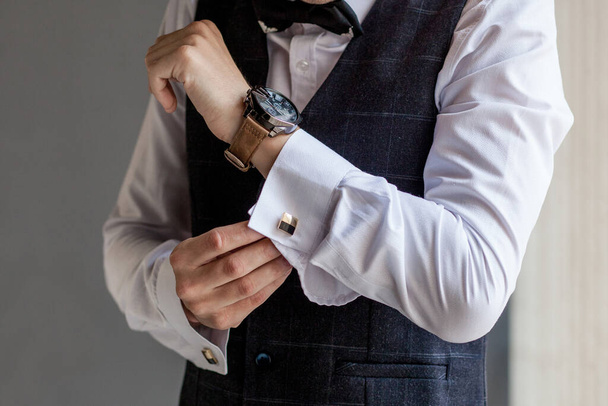 Man gets ready for work by buttoning up his business shirt. Groom's morning preparation before wedding. - Foto, imagen