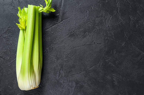 Bunch of fresh celery stalk with leaves. Black background. Top view. Space for text. - Photo, Image