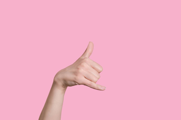 Caucasian woman hand making a call me gesture. on pink background - Фото, зображення