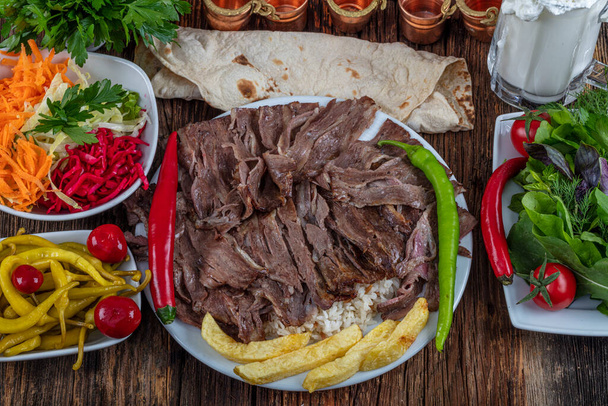 Παραδοσιακός Τούρκος Doner Kebab, shawarma ή γυρος με πίτα και ρύζι. Τουρκικό, ελληνικό ή μεσανατολικό στυλ doner kebab φαγητό σε ξύλινο τραπέζι φόντο. - Φωτογραφία, εικόνα