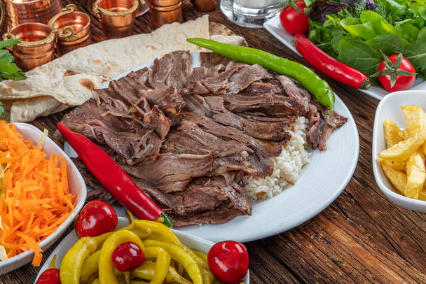 Tradicional turco Doner Kebab, shawarma o gyros con pita y arroz. Turco, griego o de estilo de Oriente Medio doner kebab alimentos sobre fondo de mesa de madera
. - Foto, Imagen