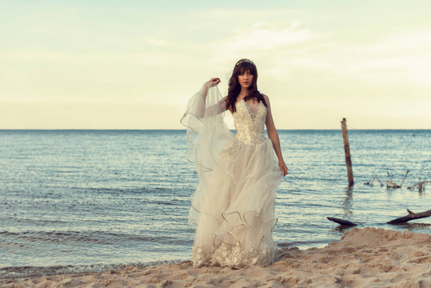 Novia en un vestido blanco junto al mar
 - Foto, Imagen
