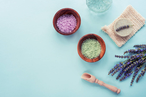 Wellness-Produkte, Seife, Meersalz, Lavendelblüten auf blauem Hintergrund. Draufsicht, flache Lage, Kopierraum - Foto, Bild