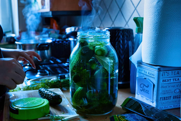 Fermer le pot en verre transparent avec cornichon de concombre avant la fumée de la cuisson dans la cuisine - Photo, image