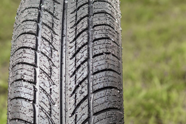 New tire. There are raindrops on it. The tread pattern is looking at us. Close-up - Photo, Image