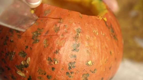 Ritagliando un occhio in una zucca per una decorazione di lanterna di Halloween da vicino - Filmati, video