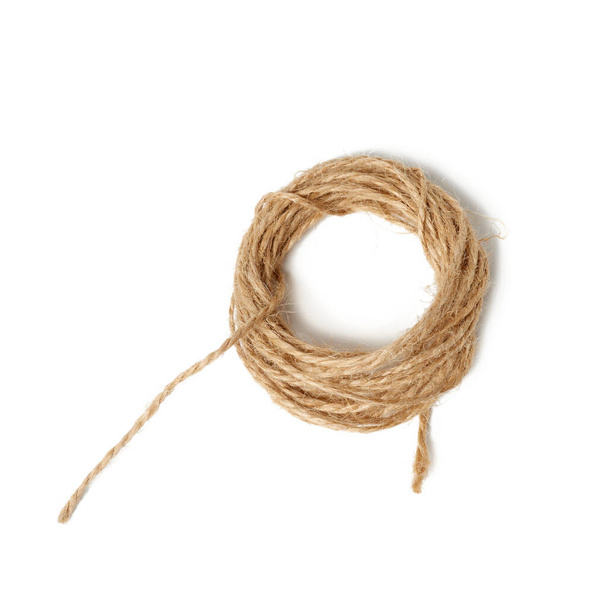 ficelle pliée brune isolée sur fond blanc, corde pour les besoins du ménage - Photo, image