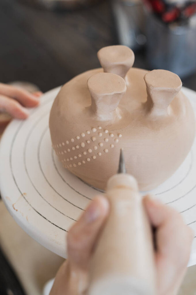 Niño en el proceso de decoración del jarrón de arcilla. Estudio de cerámica para niños. - Foto, imagen