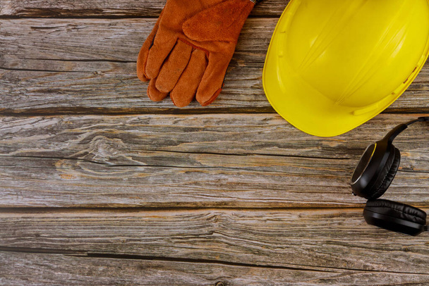 Protección ropa de trabajo seguridad construcción estándar seguridad orejeras cuero seguridad casco guantes de protección en madera mesa vista superior
 - Foto, Imagen