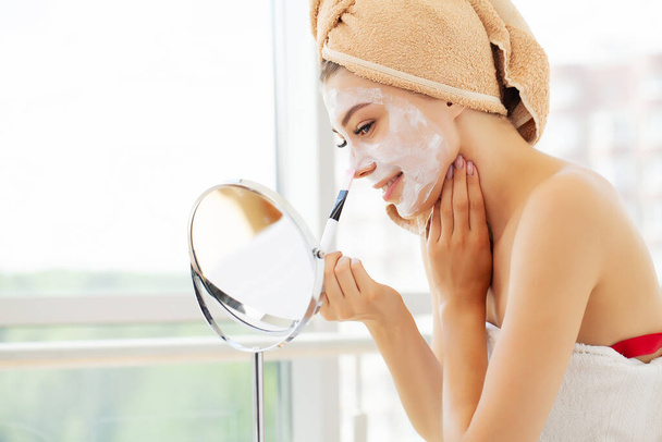 Cuidado de la piel, mujer joven con hermosa piel facial aplicando máscara en la cara
 - Foto, Imagen