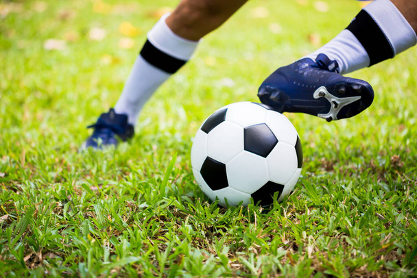 サッカー選手のコントロールは、目標に緑の芝生の上でボールを撮影する。試合のためのサッカー選手トレーニング。サッカーアカデミーのサッカー選手. - 写真・画像