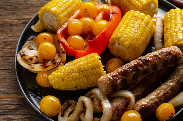 Гриль барбекю колбасы с овощами, специями и три сау е на деревянном
 - Фото, изображение