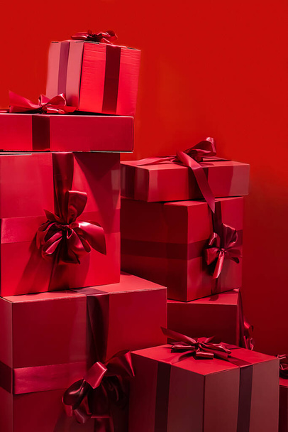 Large gift boxes with a bow on a red background. - Foto, Imagen