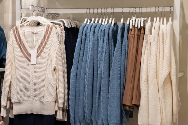 Stijlvolle modieuze kleding op hangers in een winkel. - Foto, afbeelding