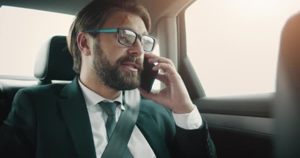 Serious businessman having conversation on way to work - Video