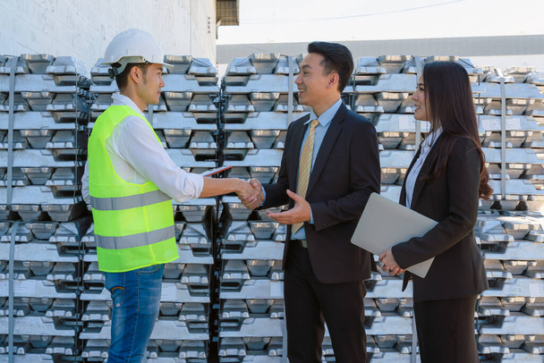 asian businessman having business discussion with executive engineeer at raw metal ingot storage warehouse for aluminum trading business - Photo, Image