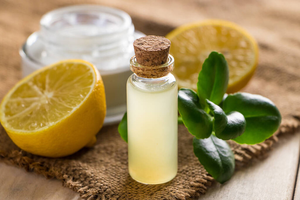 Health care concept. Organic cosmetics with lemon. Natural moisturizer on a wooden background. - Photo, Image