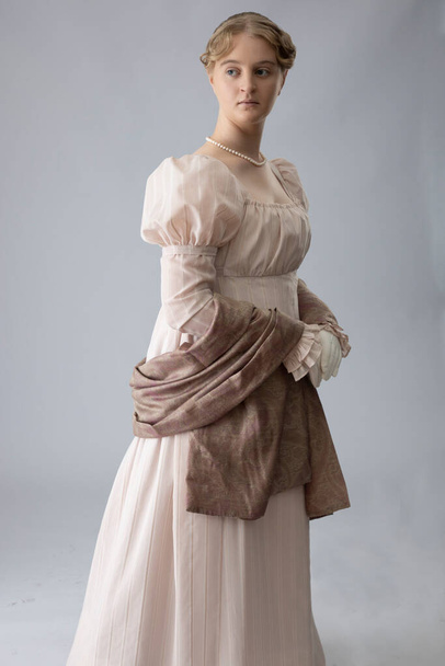 Une jeune femme Regency portant une robe rose et un collier de perles  - Photo, image