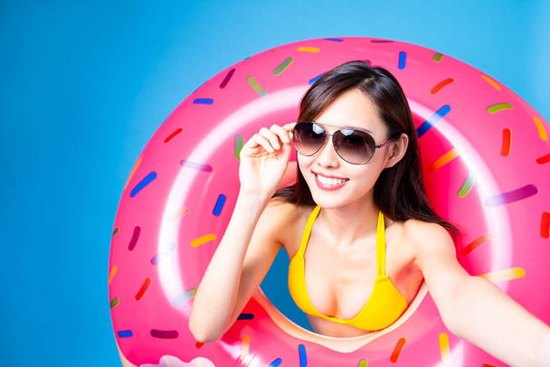 Asyalı bikinili kız selfie çek ve donut yüzme yüzüğüyle seyahat etmeye hazır ol. - Fotoğraf, Görsel