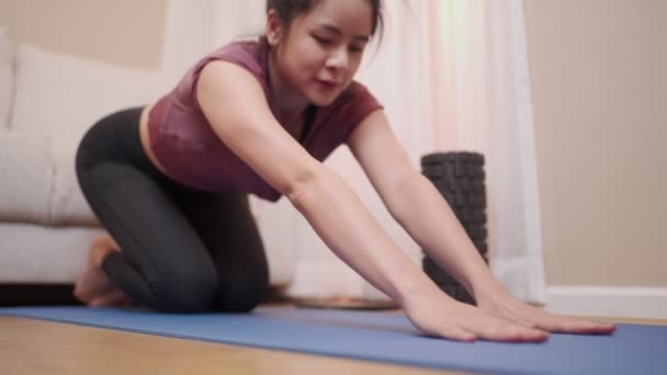 Aziatisch jong vrouw doen yoga stretch op blauwe mat, home yoga covid-19 lock down, kalme ontspanning diep adem, wellness gezond, mindcontrol stabiele emotie, lichaam flexibiliteit met yoga stretching - Video