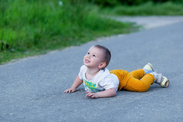 Cute toddler boy fell on park road - Фото, изображение