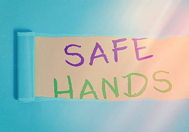 Kézírás szöveg írás Biztonságos kezek. Koncepció jelentése Biztosítása a sterilitás és tisztaság a kezét a fertőtlenítés gördülő szakadt karton felett elhelyezett fa klasszikus asztal háttér. - Fotó, kép