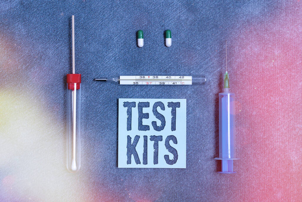 Écriture manuscrite de texte Test Kits. Concept signifiant outils utilisés pour détecter la présence de quelque chose dans le corps Ensemble d'équipements médicaux avec bloc-notes pour l'évaluation de l'état de santé. - Photo, image