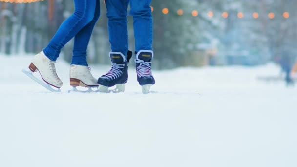 para w niebieskich dżinsach i łyżwach stoi na lodowisku publicznym - Materiał filmowy, wideo