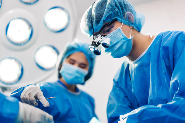 Profesjonalny anestezjolog lekarz zespół medyczny i asystent przygotowujący pacjenta do zabiegu ginekologicznego wykonującego operacje operacyjne ze sprzętem chirurgicznym w nowoczesnym szpitalu ambulatorium - Zdjęcie, obraz
