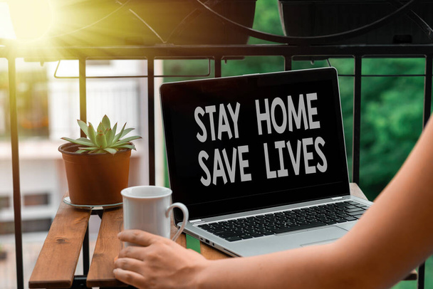 Textschild mit der Aufschrift Stay Home Save Life. Konzeptfotos verringern die Anzahl der infizierten Patienten, indem sie das Haus nicht verlassen Persönliche Arbeitsplatzübersicht mit Laptop-Gerät, das für individuelle Interessen verwendet wird. - Foto, Bild