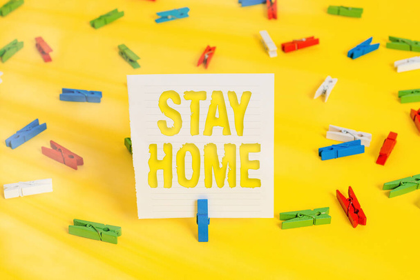 Conceptual hand writing showing Stay Home. Business photo showcasing not go out for an activity and stay inside the house or home Colored clothespin papers empty reminder yellow floor office. - 写真・画像