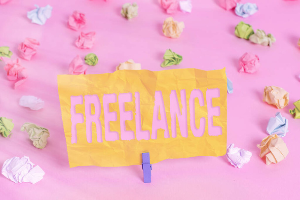 Handwriting text writing Freelance. Concept meaning working at different firms rather than being permanently Colored crumpled papers empty reminder pink floor background clothespin. - Photo, Image