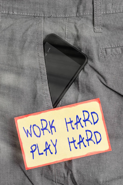 Handschrift Textschreiben Work Hard Play Hard. Konzept bedeutet fleißig in jeder Aktivität Party am Wochenende Fleißiges Smartphone-Gerät in formaler Arbeitshosentasche neben Notizpapier. - Foto, Bild