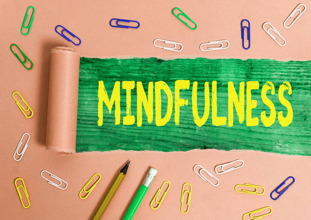 Writing note showing Mindfulness. Business photo showcasing state of mind attained by concentrating one s is attention Rolled ripped torn cardboard above a wooden classic table. - Photo, Image