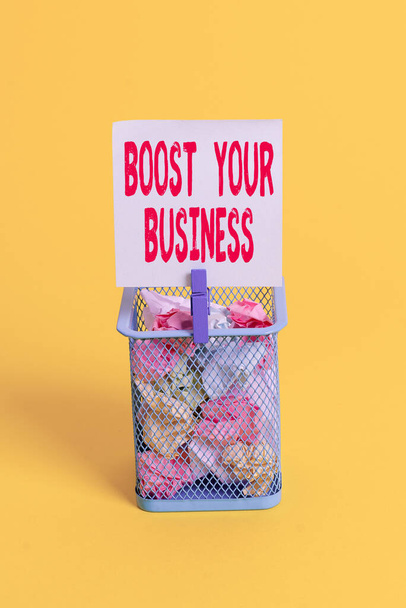 Conceptual hand writing showing Boost Your Business. Business photo text Suitable for web Landing page, web page design to increase profit Trash bin crumpled paper clothespin office supplies yellow. - Photo, Image