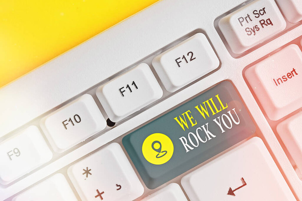 Textschild mit der Aufschrift We Will Rock You. Konzeptionelles Foto, das in die Welt hinausgeht und alles sieht, was darin ist Weiße PC-Tastatur mit leerem Notizpapier über weißem Kopierraum für Tasten. - Foto, Bild