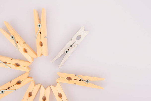 Leader concept. Think creatively. Stand out from the crowd. A silver clothespin stands out among the wooden clothespins. - Zdjęcie, obraz
