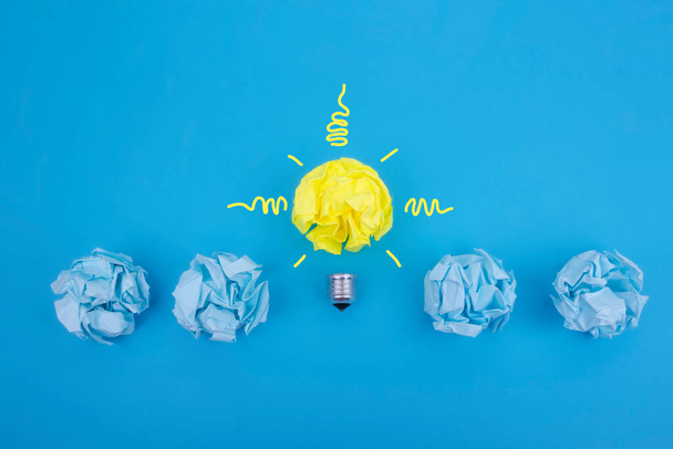 Inspiration crumpled paper concept light bulb metaphor for choosing the best idea, be different. - 写真・画像