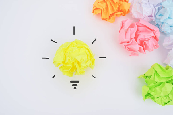 Come up with a creative idea. Crumpled paper symbolizing various solutions with one highlighted as a light bulb as the correct one. - Valokuva, kuva