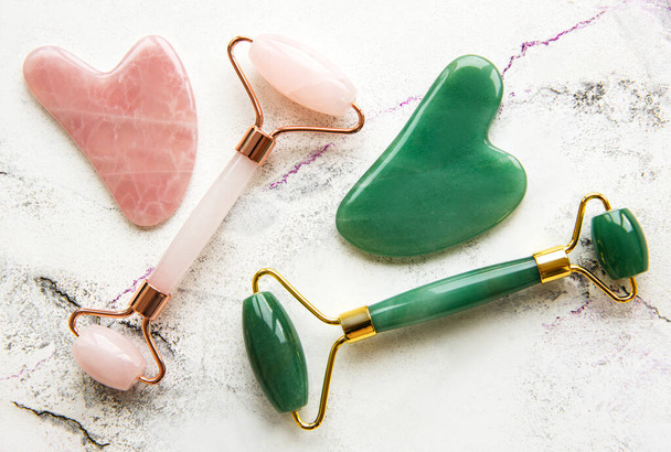 Jade face rollers for beauty facial massage therapy. Flat lay on marble background - Photo, Image