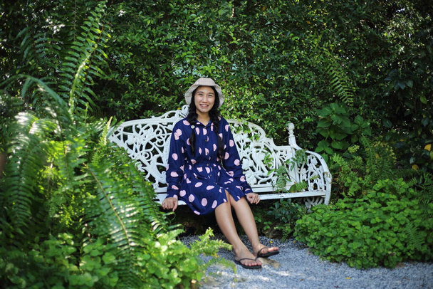 Nő ül a kertben zöld növények - Fotó, kép