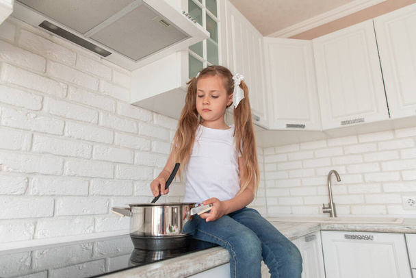 beautiful little girl with a pan and the ladle. Copy space - Photo, image