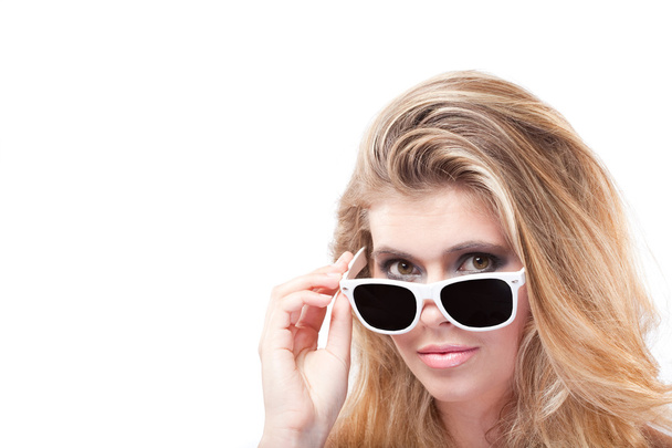 schöne blonde Frau lugt unter Sonnenbrille hervor - Foto, Bild