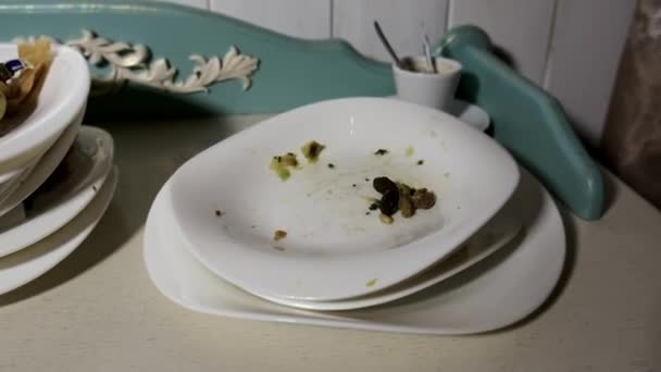 Pile di piatti sporchi con resti di cibo raccolti dai tavoli dei banchetti nel ristorante. - Filmati, video