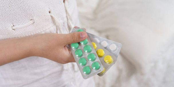 Sick teenage girl spills pills on her hand. Medical concept. - Fotó, kép