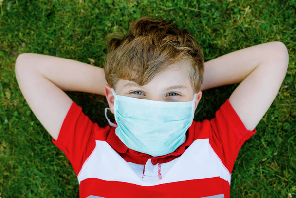 Чарівний хлопчик у медичній масці як захист від пандемії коронавірусної хвороби. Шкільна дитина використовує захисне обладнання як боротьбу з ковадлом 19
. - Фото, зображення