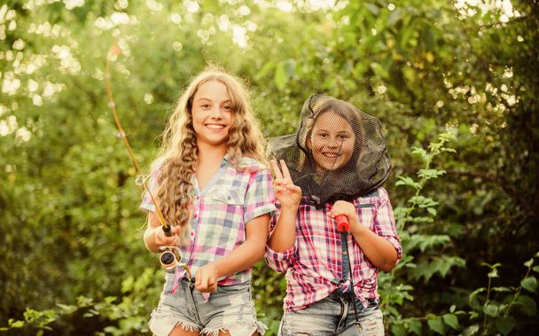Having fun. Fly fishing. Kids spend time together fishing. Fishing skills. Summer hobby. Happy smiling children with net and rod. Happy childhood. Adorable girls nature background. Teamwork - Foto, Bild